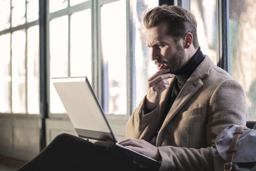 Person looking concerned while reading an email on a laptop