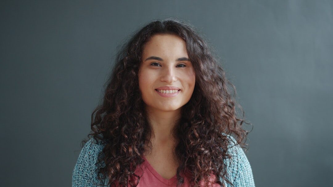 Studio portrait of a smiling woman with curly hair