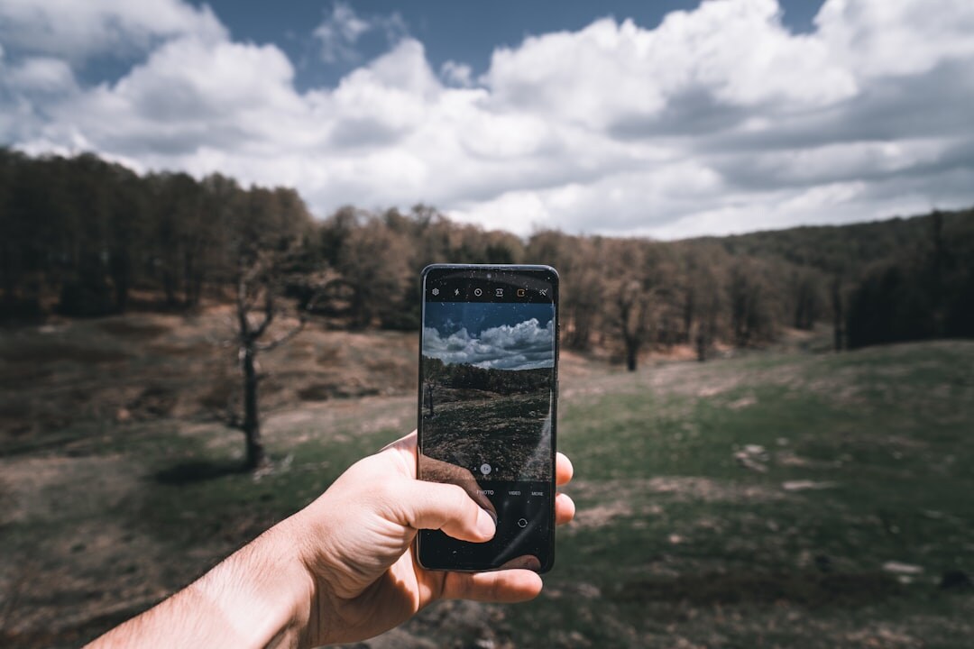 Person holding and using a smartphone outdoors