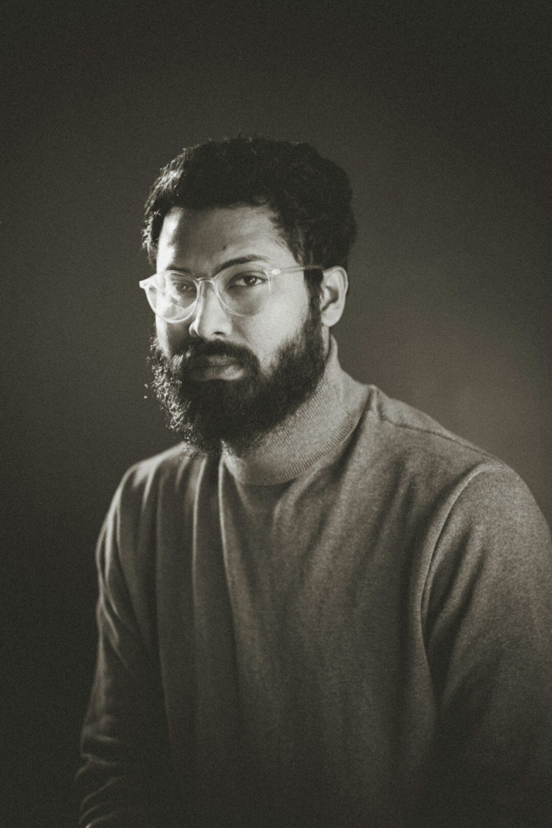 Studio portrait of a man with a beard and glasses