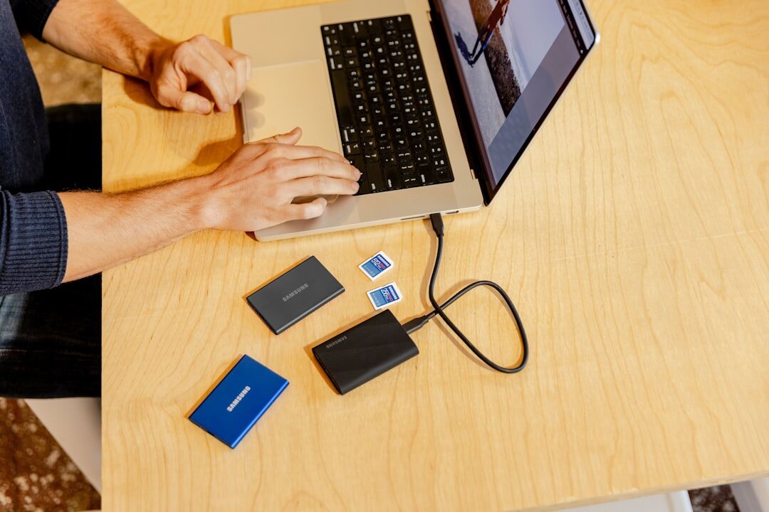 Hands connecting an external hard drive to a laptop for backup